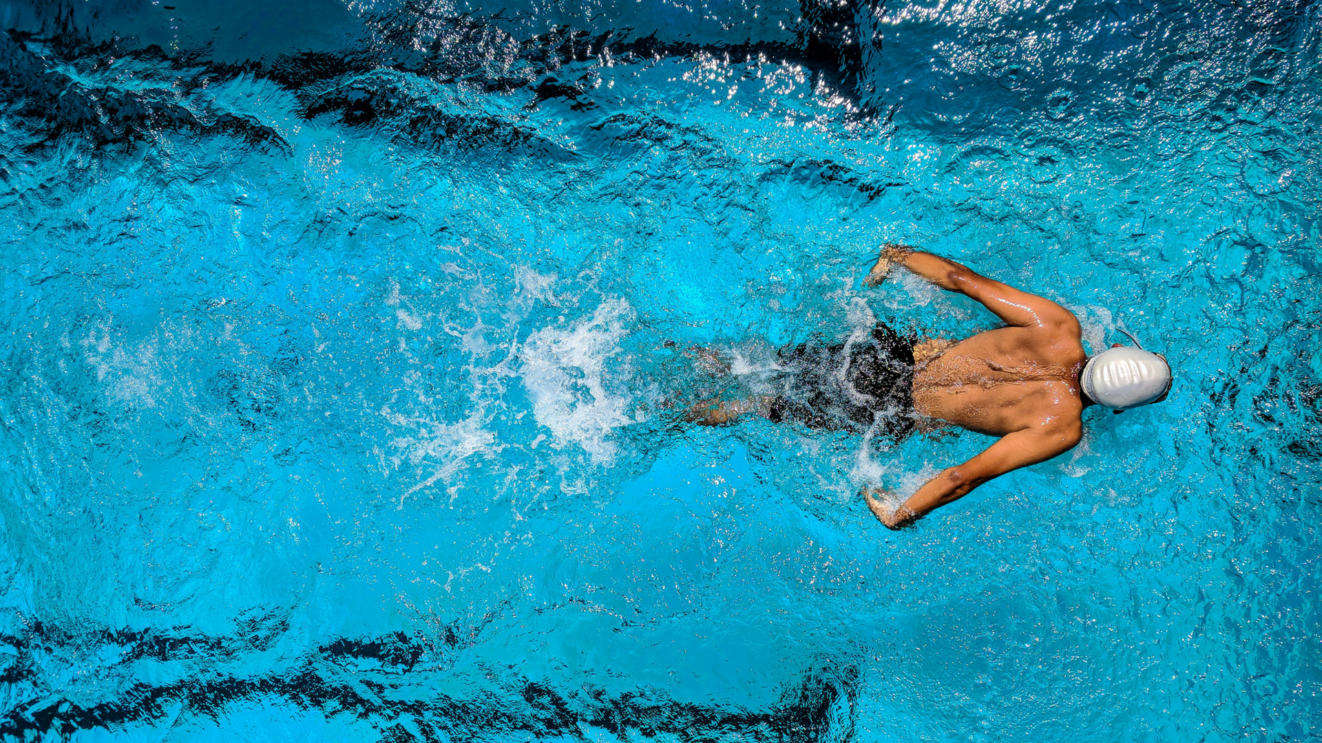 man swimming in blue pool